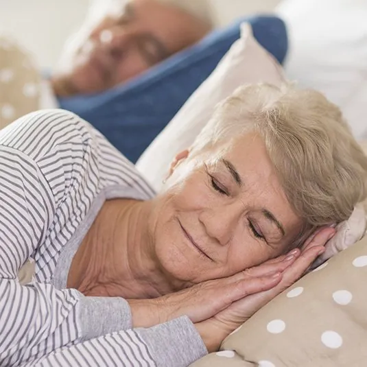 An older woman sleeping peacefully in her bed