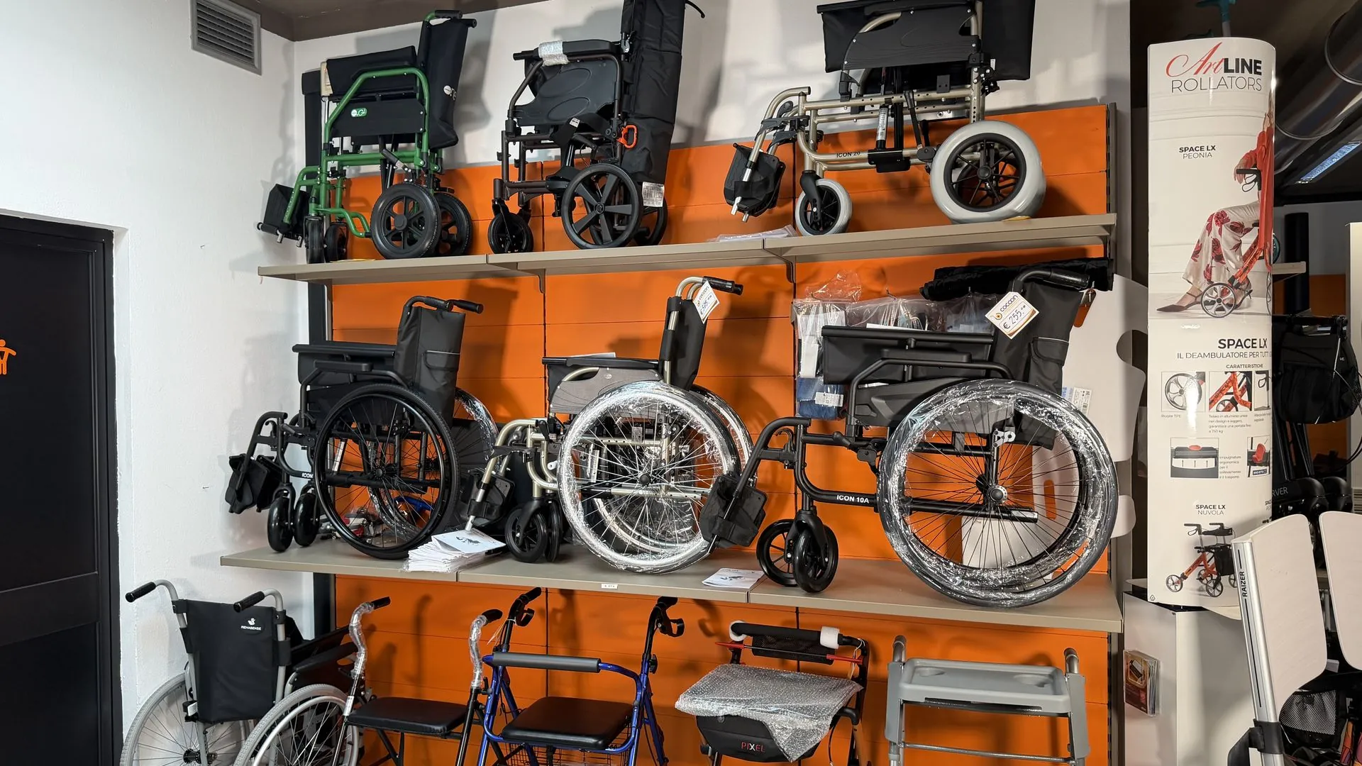 Wheelchairs and rollators on display on the wall of the Cocoon shop