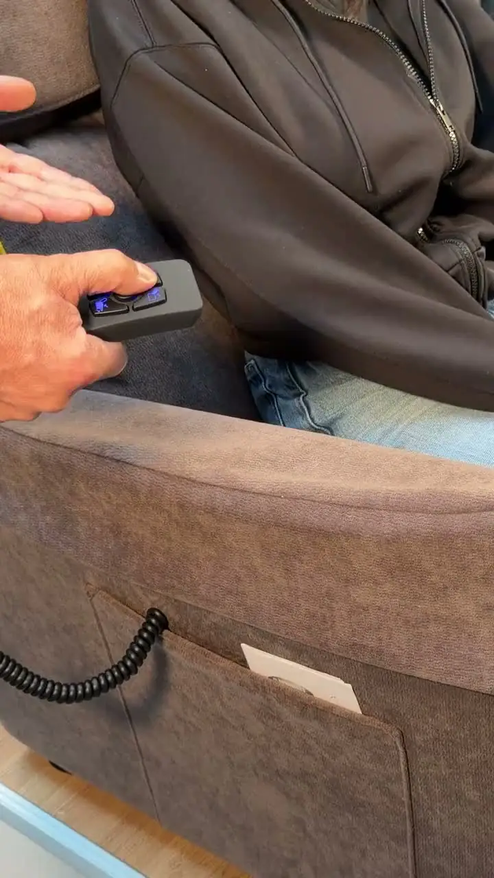 The remote control of a lift chair next to the armrest, in the Cocoon store