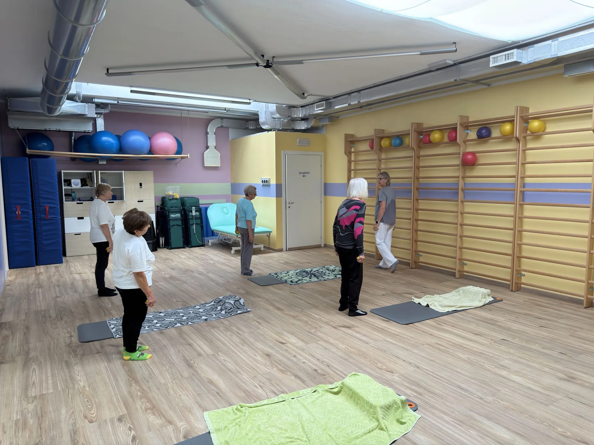 Allieve della ginnastica dolce alla spalliera con l’insegnante